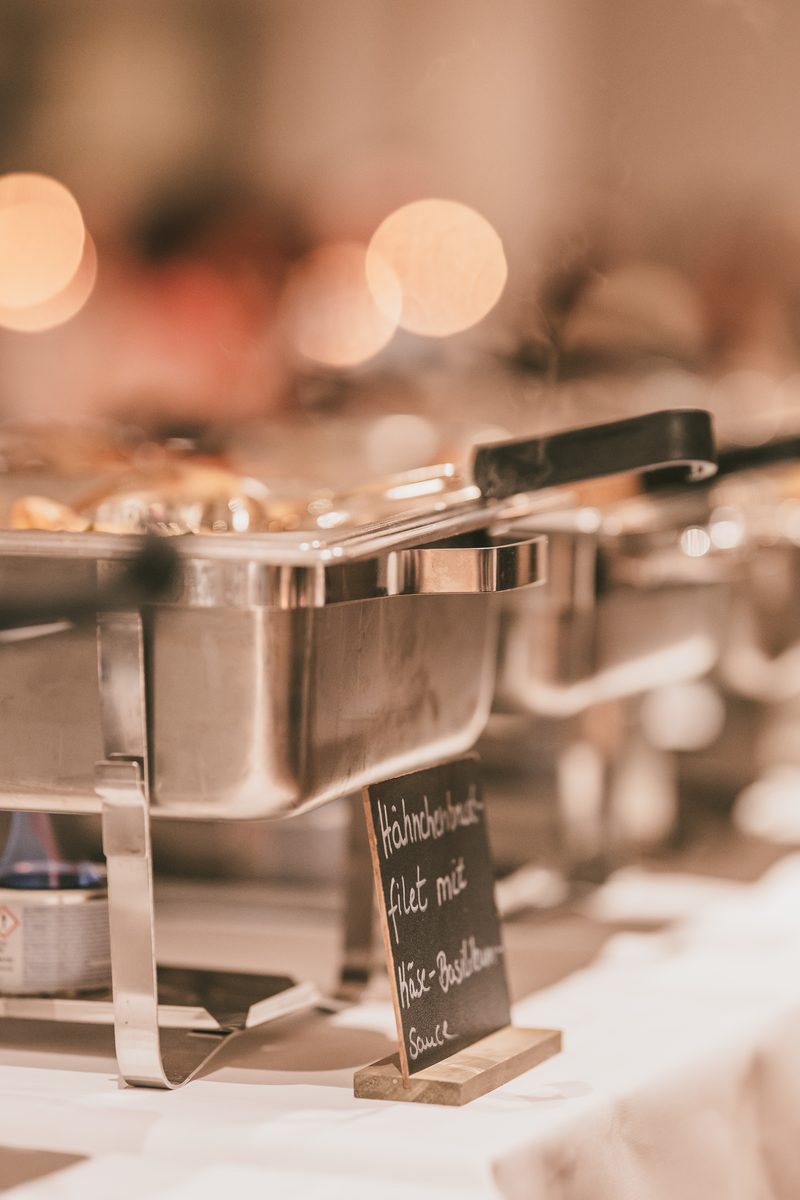 Warmhaltebehälter auf dem Buffet mit handgeschriebenem Schild