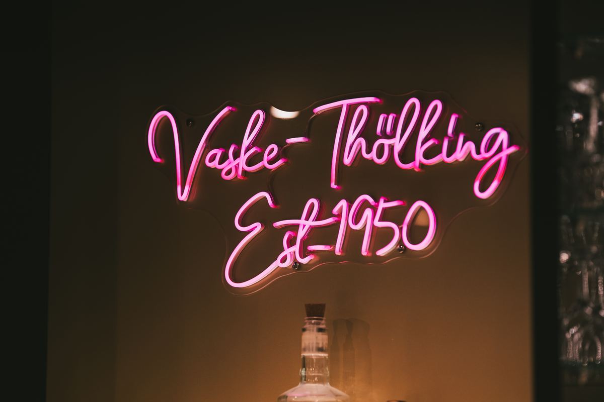 Leuchtschrift „Vaske-Thölking Est. 1950“ an einer dunklen Wand