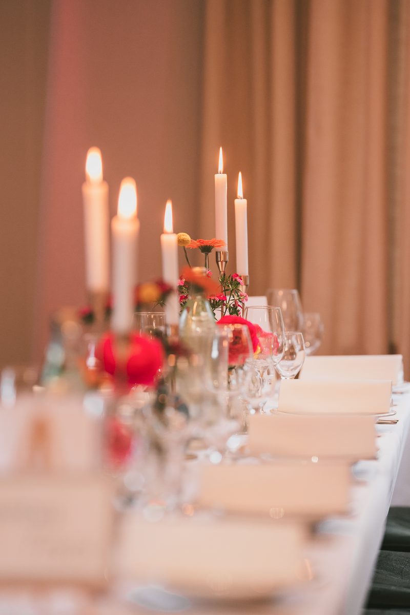 Festlich gedeckte Tafel mit hohen Kerzen und roten Rosen