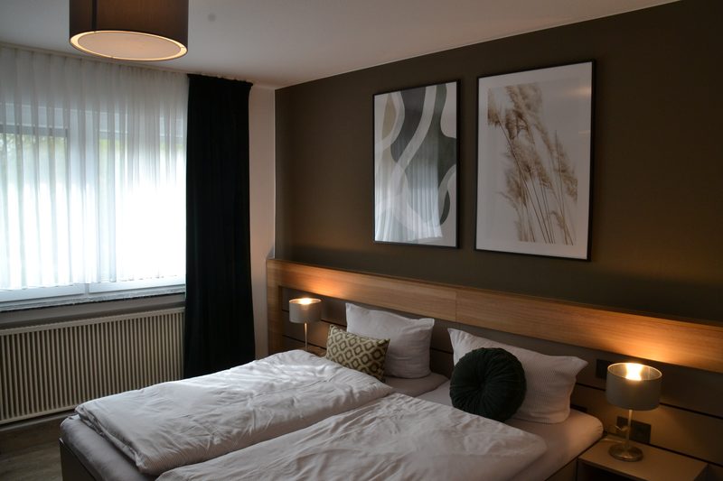 Gästezimmer mit Doppelbett und Nachttischlampen